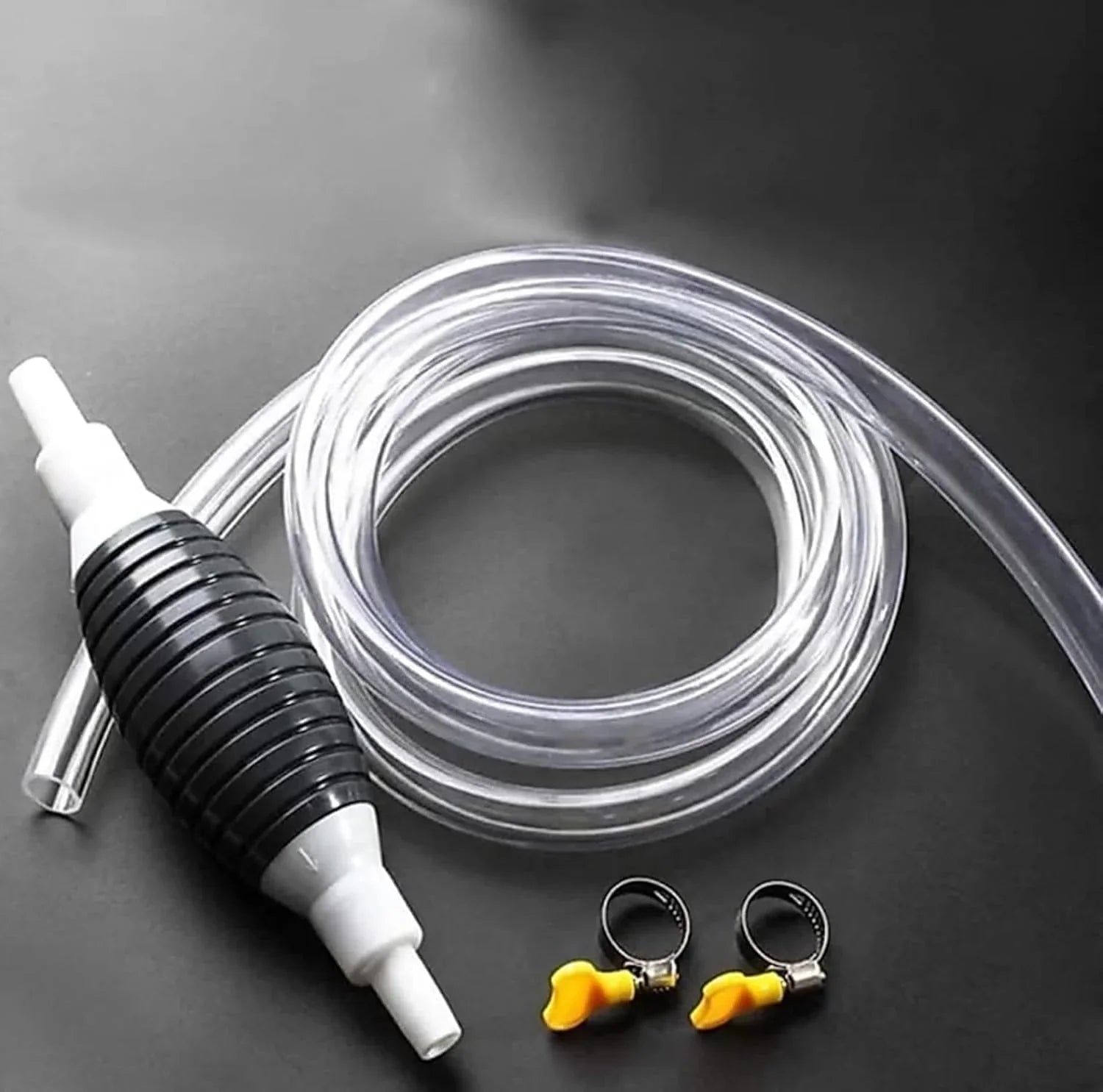 Clear hose with black and white pump and small clips on a dark background