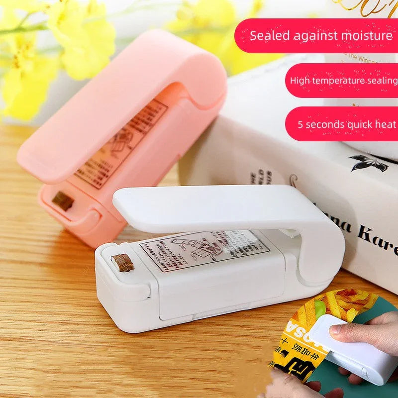 White sealing device with pink cover on a wooden surface, surrounded by yellow flowers.