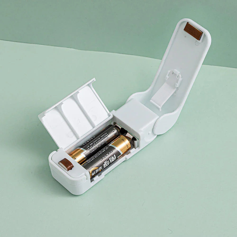 White battery charger with batteries on a light green background